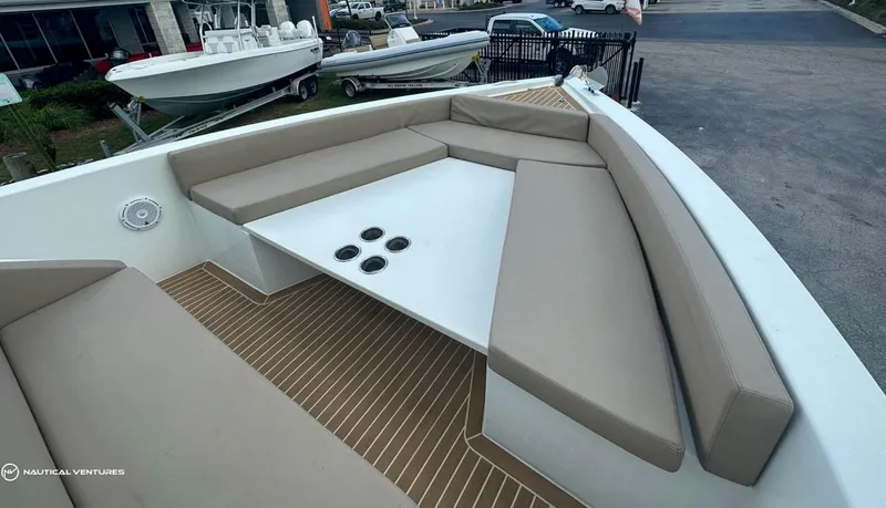  Yacht Photos Pics 2022 De Antonio Yachts D34 Xplorer, spacious seating area with beige cushions and a central table.