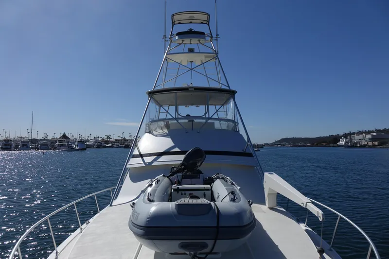 Aquila II Yacht Photos Pics 1990 Bertram 50 Convertible yacht with inflatable boat on deck, docked in a marina.