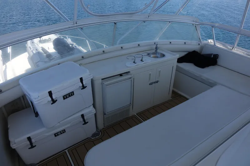 Aquila II Yacht Photos Pics 1990 Bertram 50 Convertible yacht interior with seating, coolers, and sink on deck.
