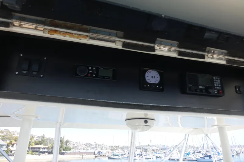 Aquila II Yacht Photos Pics Control panel of a 1990 Bertram 50 Convertible boat with marina view.