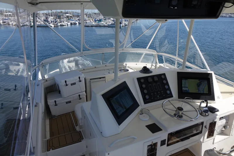 Aquila II Yacht Photos Pics Cockpit view of 1990 Bertram 50 Convertible yacht with navigation equipment and marina backdrop.