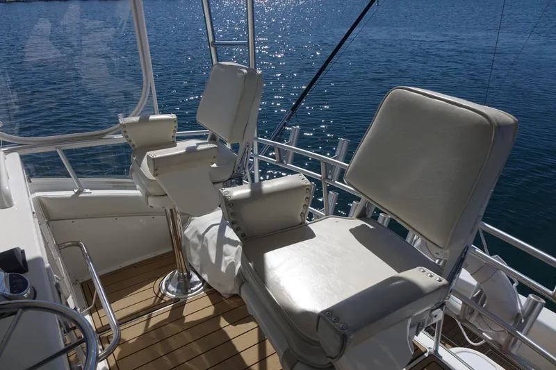 Aquila II Yacht Photos Pics 1990 Bertram 50 Convertible yacht helm with white captain chairs and ocean view.