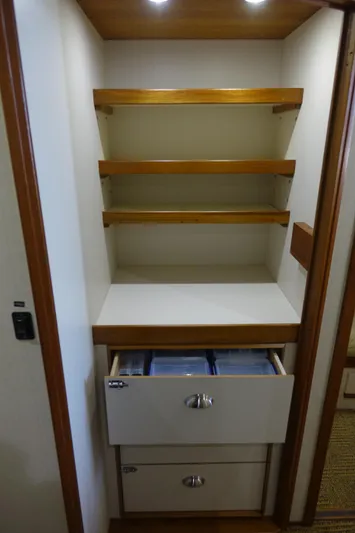 Aquila II Yacht Photos Pics 1990 Bertram 50 Convertible interior with wooden shelves and drawers.