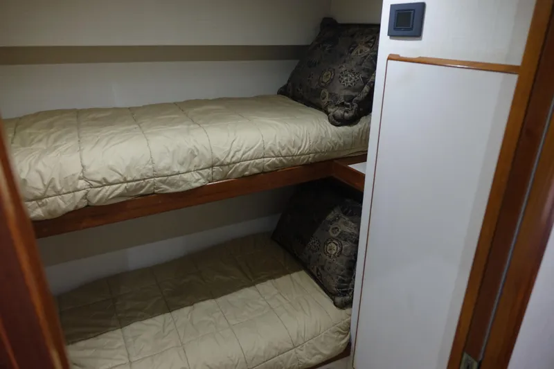 Aquila II Yacht Photos Pics Bunk beds in a 1990 Bertram 50 Convertible yacht cabin with beige bedding.