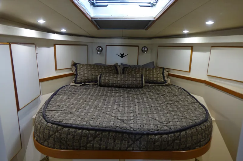 Aquila II Yacht Photos Pics Luxurious bedroom interior of 1990 Bertram 50 Convertible yacht with skylight and elegant bedding.