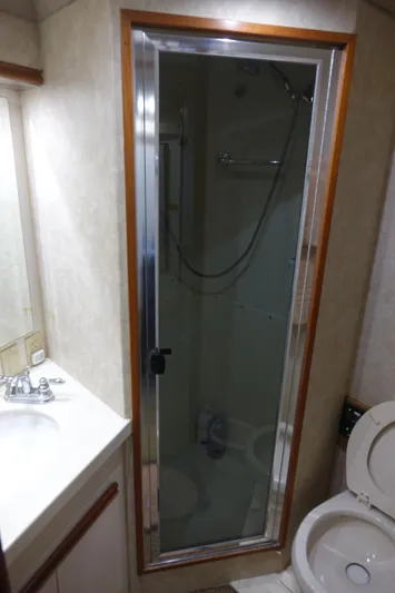 Aquila II Yacht Photos Pics 1990 Bertram 50 Convertible yacht bathroom with shower, sink, and toilet.