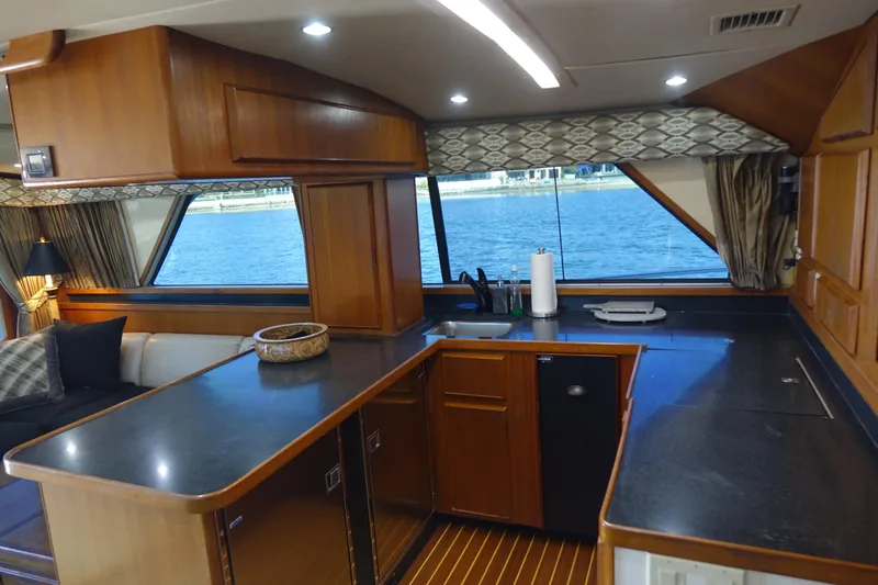 Aquila II Yacht Photos Pics Interior of 1990 Bertram 50 Convertible yacht with modern kitchen and waterfront view.