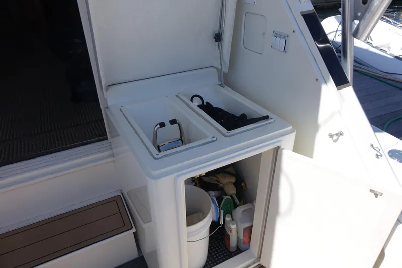 Aquila II Yacht Photos Pics 1990 Bertram 50 Convertible yacht interior with storage compartments and cleaning supplies.