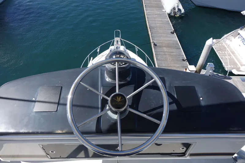 Aquila II Yacht Photos Pics Helm of 1990 Bertram 50 Convertible yacht at dock, overlooking water.