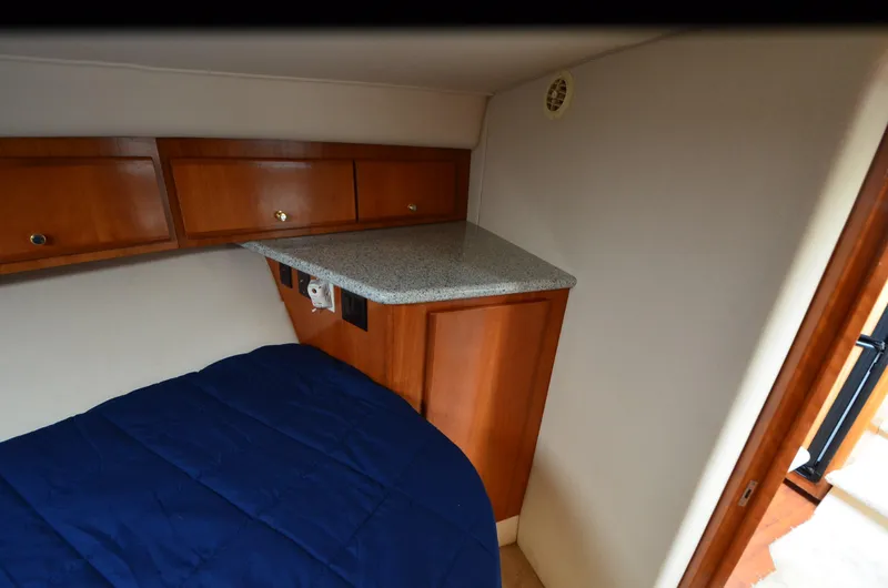 Radio Wave Yacht Photos Pics 2001 Carver 406 cabin interior with wooden cabinets and blue bedding.