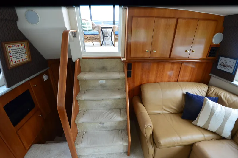 Radio Wave Yacht Photos Pics Interior of 2001 Carver 406 yacht with stairs, leather sofa, and wooden cabinets.