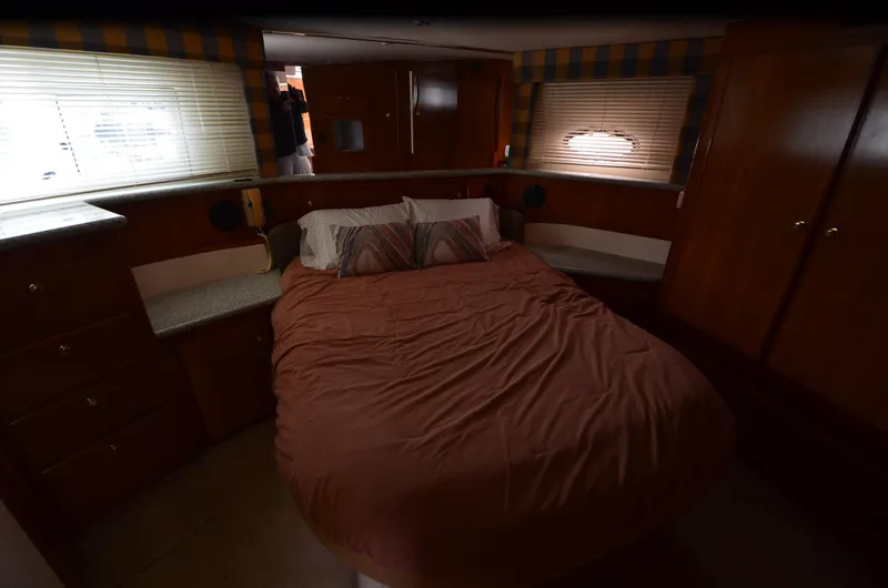 Radio Wave Yacht Photos Pics Cozy bedroom interior of 2001 Carver 406 yacht with wood cabinetry and soft lighting.