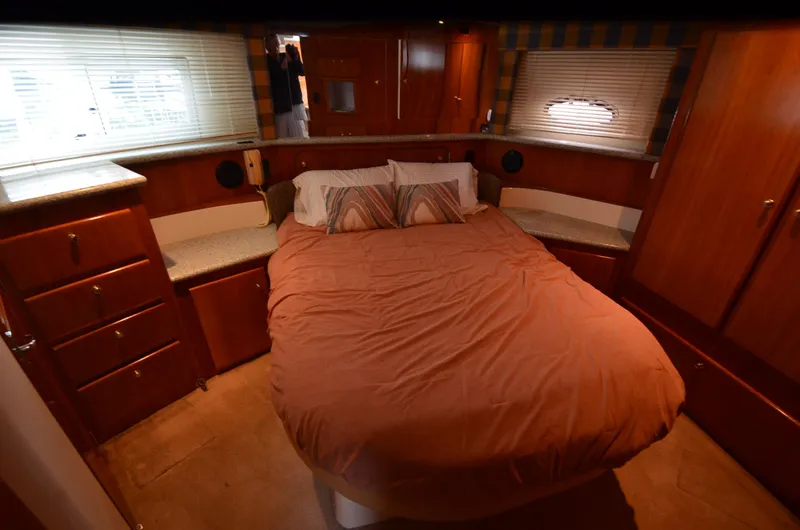 Radio Wave Yacht Photos Pics Luxurious bedroom interior of 2001 Carver 406 yacht with cozy bed and wooden cabinetry.