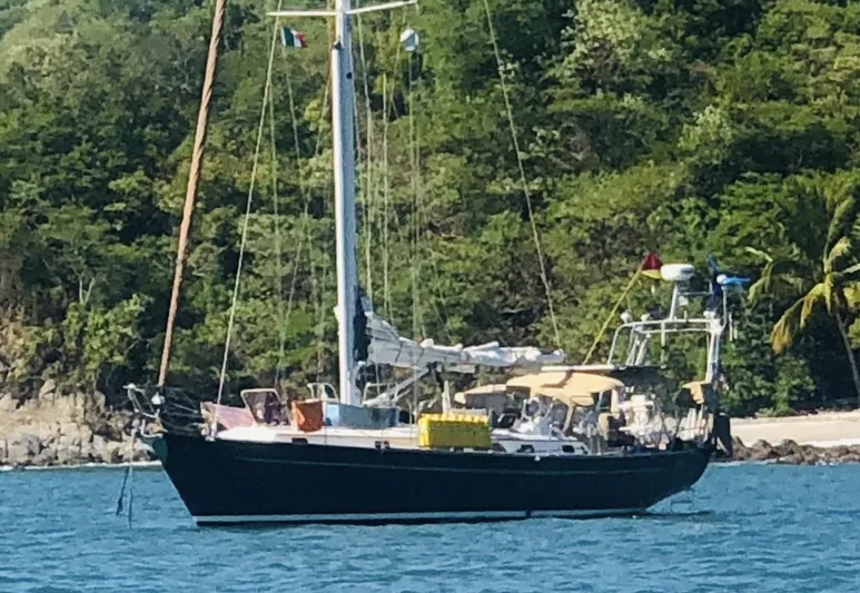 Joy Yacht Photos Pics Sailboat "Passport Royal 43" anchored near lush green shoreline, 1999 model.
