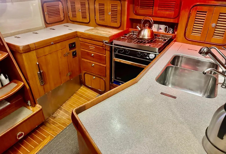 Joy Yacht Photos Pics Wooden yacht kitchen with stove, sink, and cabinets, Passport Royal 43, 1999 model.