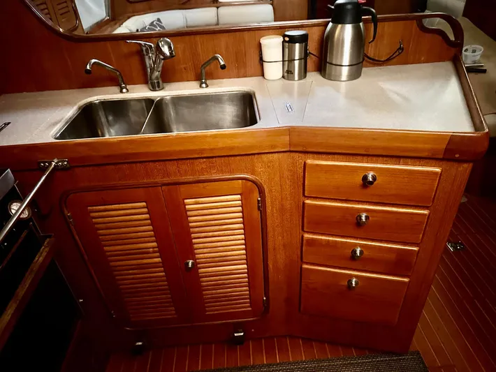Joy Yacht Photos Pics Wooden yacht kitchen with double sink, cabinets, and countertop appliances on a Passport Royal 43, 1999.