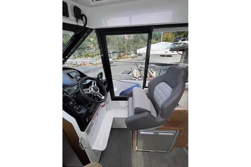  Yacht Photos Pics Interior of 2021 Jeanneau NC Sport 895 boat with steering wheel and captain's chair.