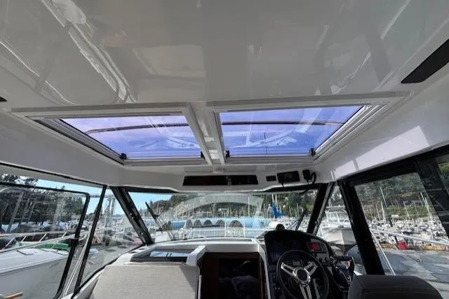  Yacht Photos Pics Interior view of 2021 Jeanneau NC Sport 895 boat with sunroof and steering wheel.