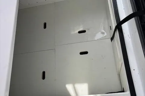  Yacht Photos Pics Storage compartment on a 2021 Jeanneau NC Sport 895 boat, featuring white panels and black handles.