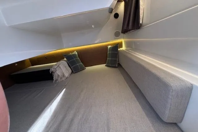  Yacht Photos Pics Interior cabin of 2021 Jeanneau NC Sport 895 with cozy bedding and cushions.