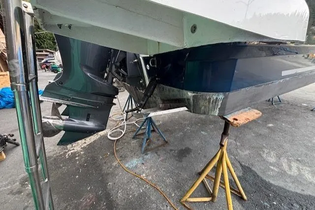  Yacht Photos Pics 2021 Jeanneau NC Sport 895 boat on stands, showing outboard motor and hull.