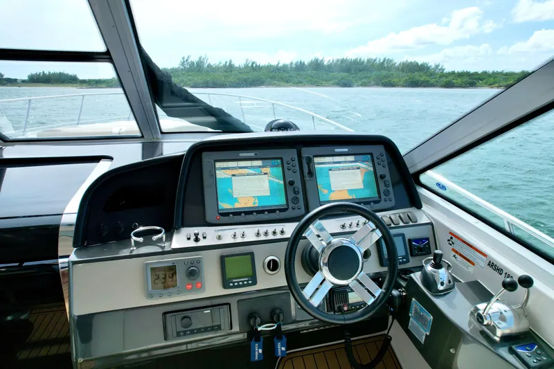 Epic Yacht Photos Pics 2009 Four Winns V458 yacht cockpit with navigation screens and steering wheel, cruising on open water.
