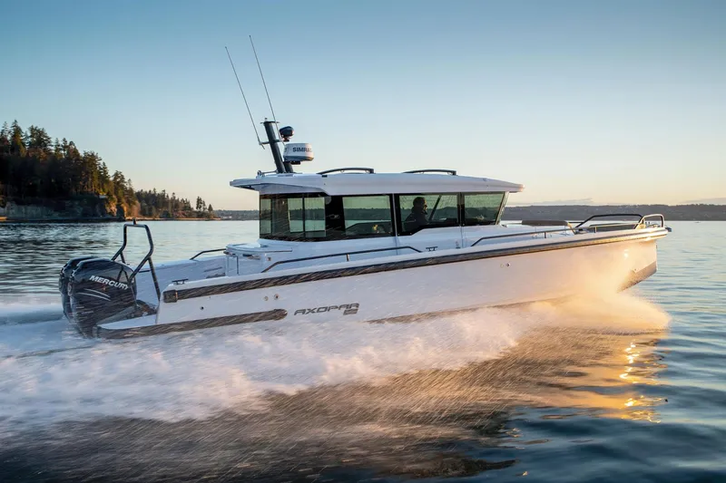  Yacht Photos Pics 2022 Axopar 37 Cross Cabin boat cruising on a serene lake at sunset.