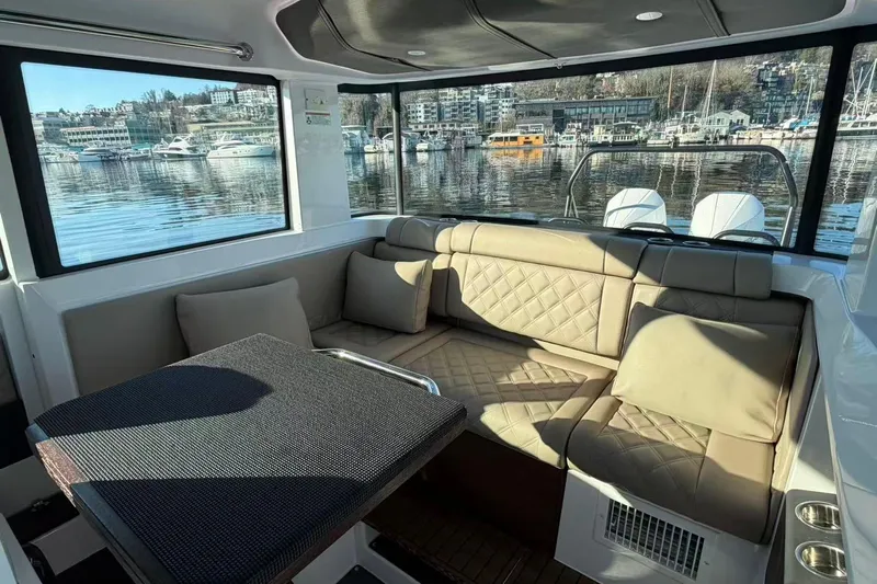  Yacht Photos Pics Interior of 2022 Axopar 37 XC Cross Cabin with beige seating and waterfront view.