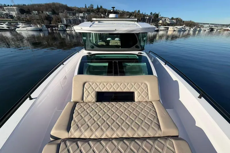  Yacht Photos Pics 2022 Axopar 37 XC Cross Cabin boat with luxurious seating, docked in a serene marina.