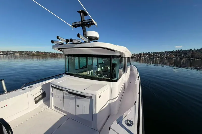  Yacht Photos Pics 2022 Axopar 37 XC Cross Cabin boat on calm water under clear blue sky.