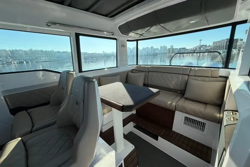  Yacht Photos Pics Interior of 2022 Axopar 37 XC Cross Cabin with luxurious seating and scenic waterfront view.