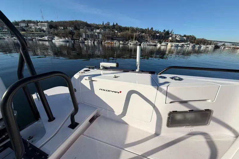  Yacht Photos Pics 2022 Axopar 37 XC Cross Cabin boat on calm water, scenic shoreline view.