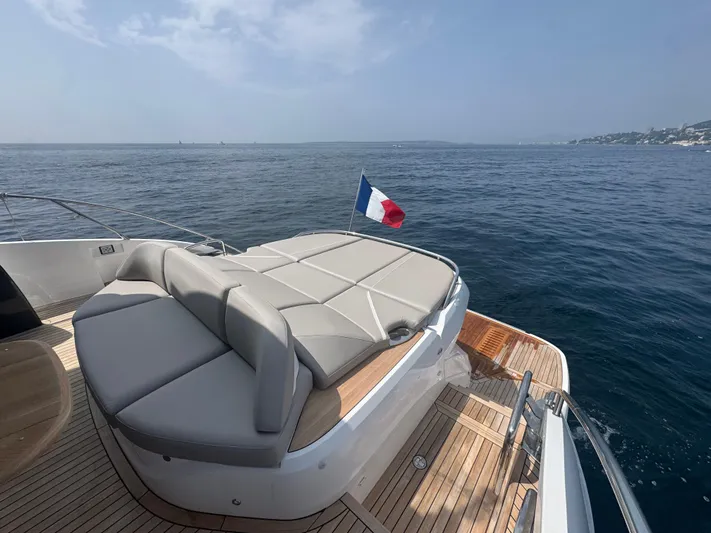  Yacht Photos Pics Luxurious 2024 Princess V55 yacht with sunbed and French flag on open sea.