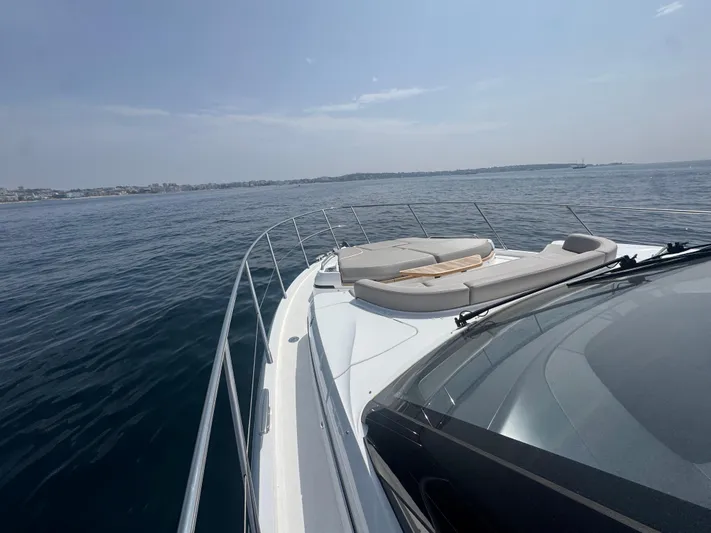  Yacht Photos Pics 2024 Princess V55 yacht cruising on open sea with luxurious deck seating.