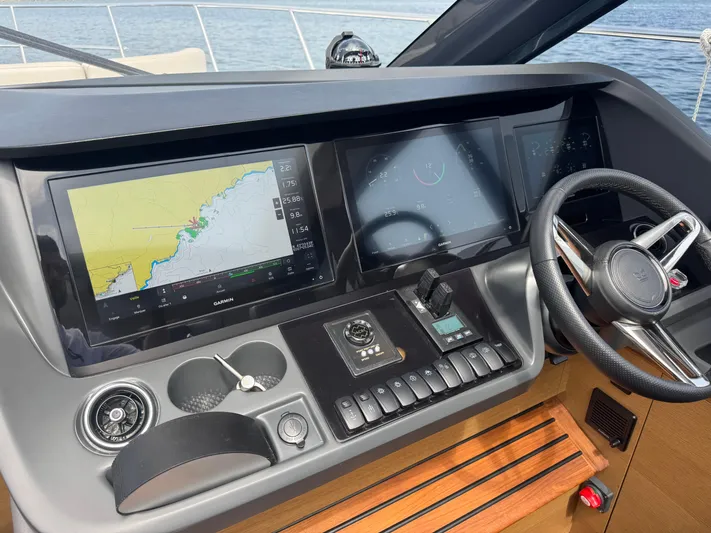  Yacht Photos Pics 2024 Princess V55 yacht helm with navigation screens and steering wheel.