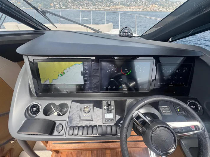  Yacht Photos Pics 2024 Princess V55 yacht dashboard with navigation screens and steering wheel.