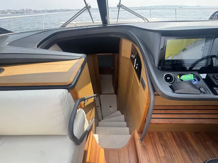  Yacht Photos Pics Interior of 2024 Princess V55 yacht with navigation screen and wooden staircase.