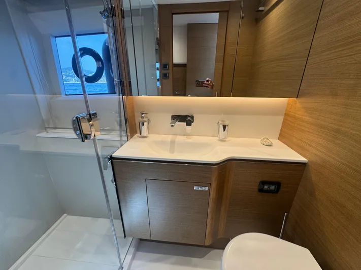  Yacht Photos Pics Luxurious bathroom interior of 2024 Princess V55 yacht with modern fixtures and wooden accents.