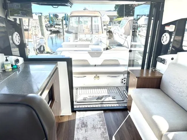 Three Beaches Yacht Photos Pics Interior view of 2020 Four Winns Vista 355 Coupe OB yacht, featuring modern seating and dockside view.