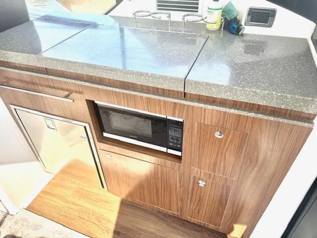 Three Beaches Yacht Photos Pics 2020 Four Winns Vista 355 Coupe OB kitchen area with microwave and compact fridge.