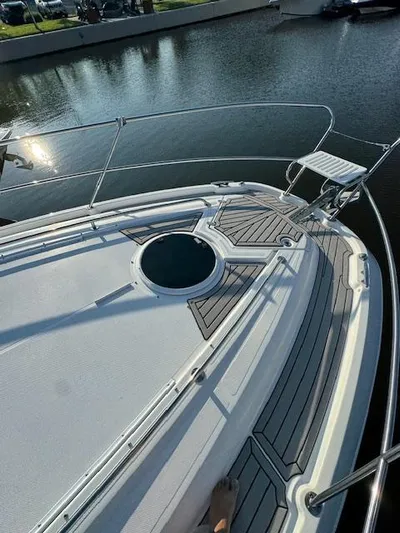 Three Beaches Yacht Photos Pics 2020 Four Winns Vista 355 Coupe OB boat deck with railing, docked by calm water.