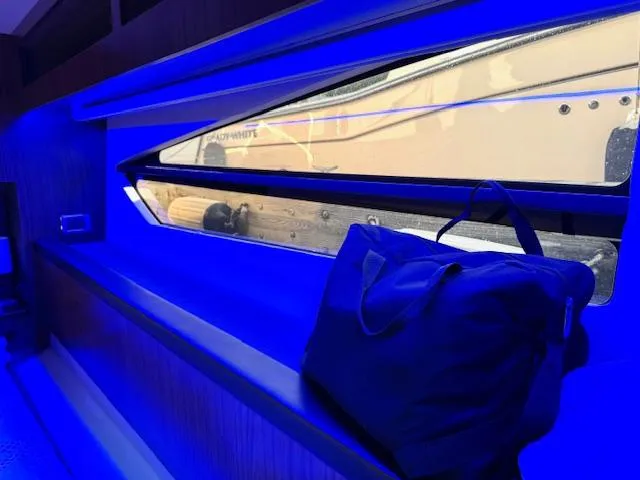 Three Beaches Yacht Photos Pics Interior of 2020 Four Winns Vista 355 Coupe OB with blue lighting and a window view.