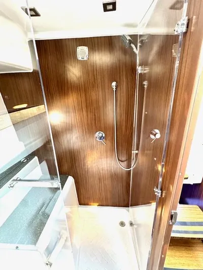 Three Beaches Yacht Photos Pics Modern shower in 2020 Four Winns Vista 355 Coupe OB boat, featuring sleek wood paneling.