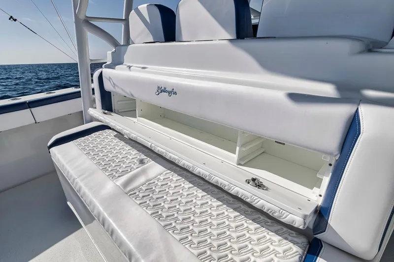  Yacht Photos Pics 2020 Yellowfin 42 Offshore boat interior with storage compartment open, showcasing seating and ocean view.