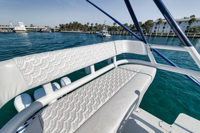  Yacht Photos Pics 2020 Yellowfin 42 Offshore boat with white seating, docked near palm trees and buildings.