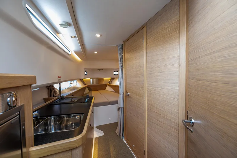 #41 Trade In Yacht Photos Pics Interior of 2022 Nimbus C11 boat with modern kitchen and cozy sleeping area.