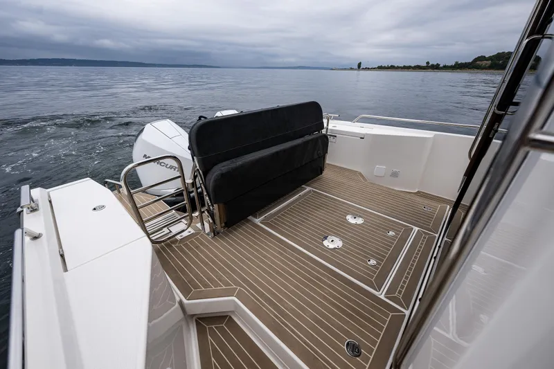 #41 Trade In Yacht Photos Pics 2022 Nimbus C11 boat deck with seating, overlooking calm waters under cloudy skies.