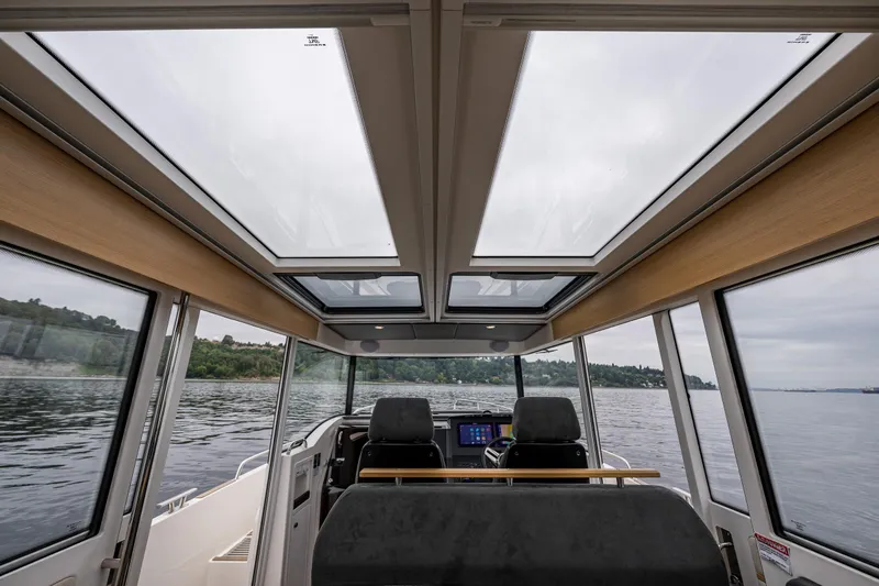 #41 Trade In Yacht Photos Pics Interior view of 2022 Nimbus C11 boat with panoramic windows and modern dashboard.