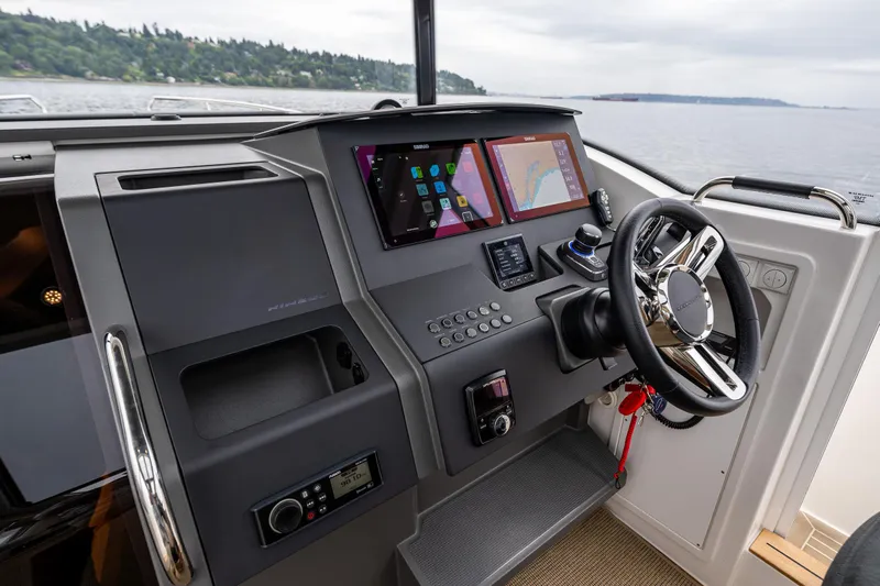#41 Trade In Yacht Photos Pics 2022 Nimbus C11 boat dashboard with modern navigation screens and steering wheel.