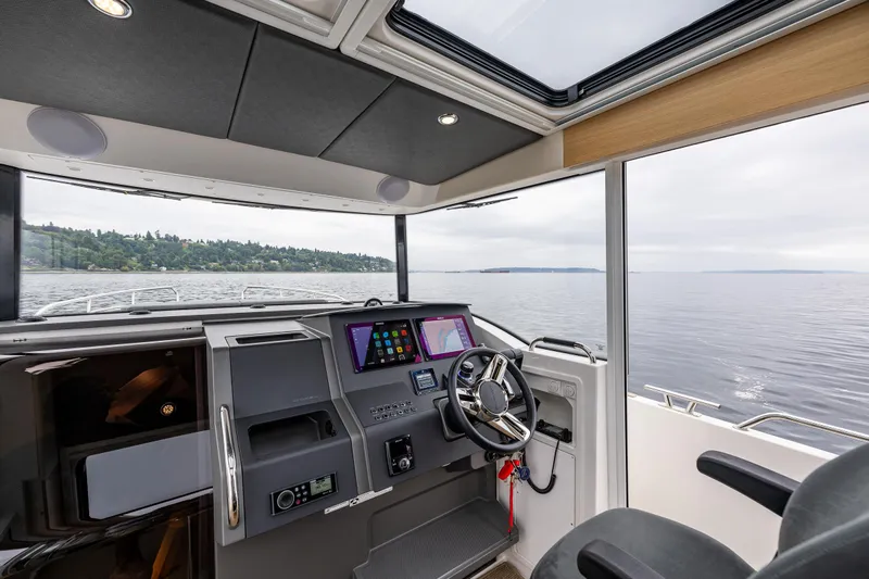 #41 Trade In Yacht Photos Pics Interior of 2022 Nimbus C11 boat with modern dashboard and scenic water view.
